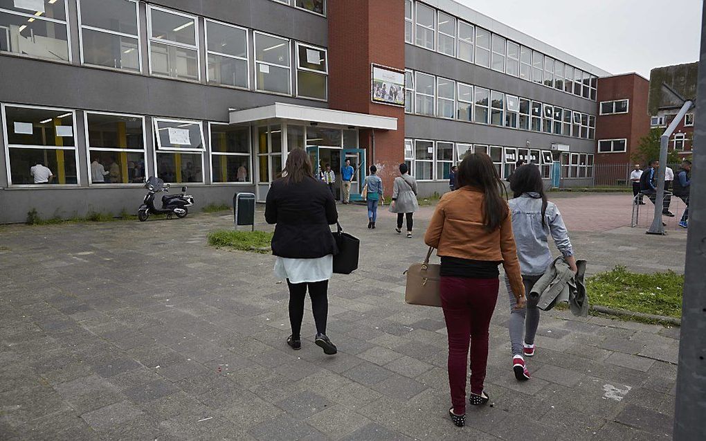 Ouders en leerlingen komen dinsdagavond aan bij de Ibn Ghaldoun school voor een informatiebijeenkomst. Foto ANP