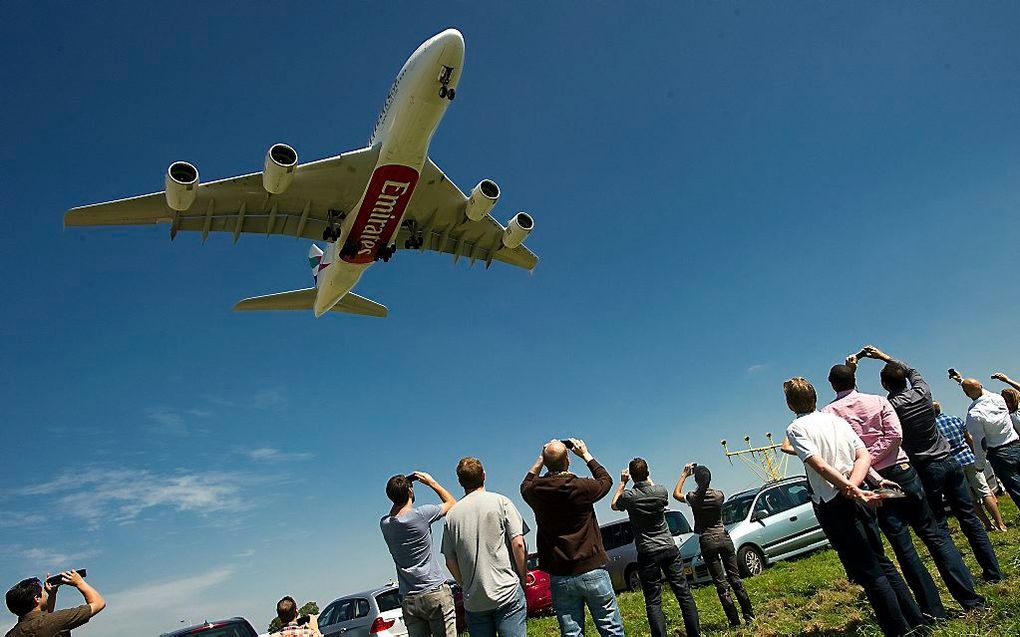 De machtige Airbus A380 scheert over de hoofden van enthousiaste vliegtuigspotters. Foto ANP