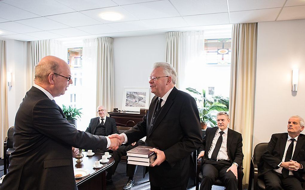 Uitgever Wim Kranendonk (l.) van uitgeverij De Banier overhandigt op de Theologische School in Rotterdam het eerste exemplaar van het boek ”Het onwankelbare verbond. Een dogmatische verkenning" aan ds. J. J. van Eckeveld, voorzitter van het curatorium en 