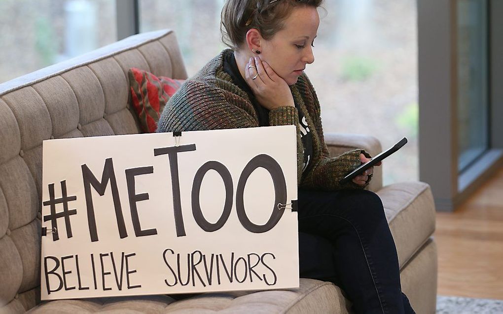 Een vrouw met een kartonnen protestbord met daarop de term ”#MeToo". beeld AFP, George Frey