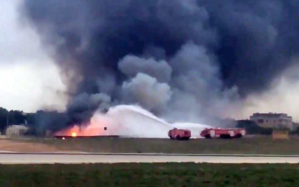 Brandweer blust het in brand gevlogen toestel op het vliegveld van Malta. beeld EPA