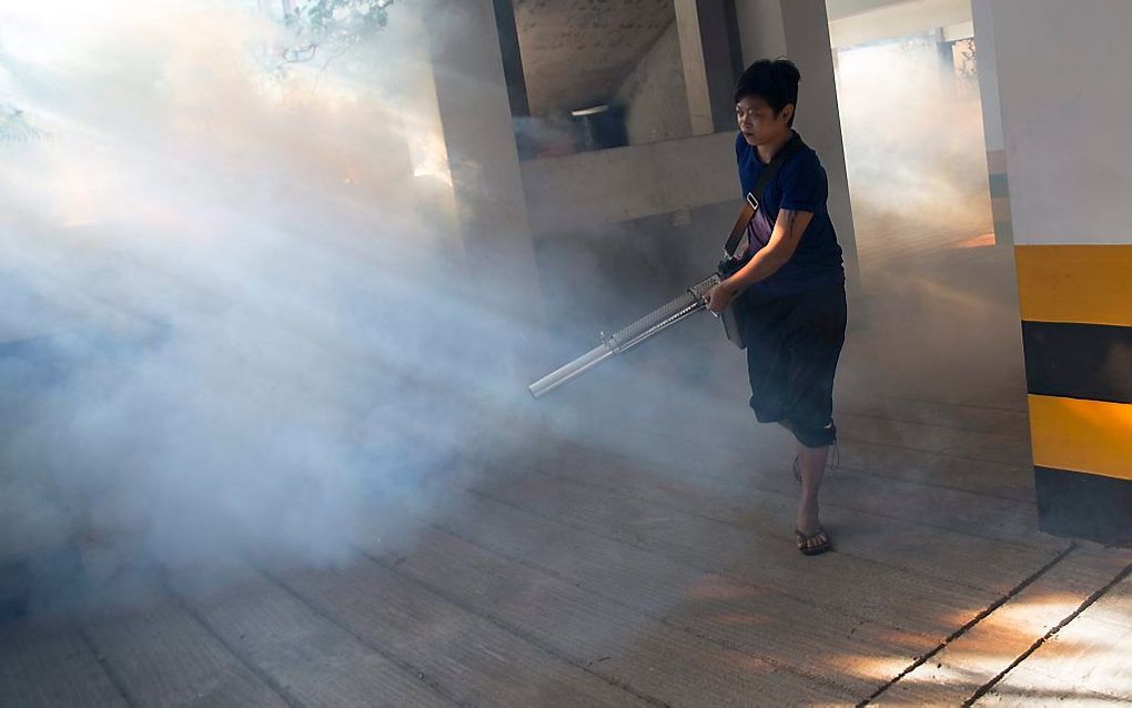 Een gezondheidswerker spuit bestrijdingsmidellen tegen muggen in de Birmese stad Rangoon (Yangon). In Birma werd op 27 oktober het eerste geval van zika vastgesteld. Het virus wordt overgebracht door muggen. beeld EPA, Lynn Bo Bo