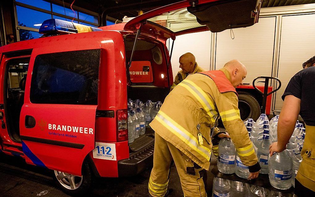 De brandweer verzamelt water om uit te delen aan risicogroepen die zijn getroffen door een waterstoring. beeld ANP