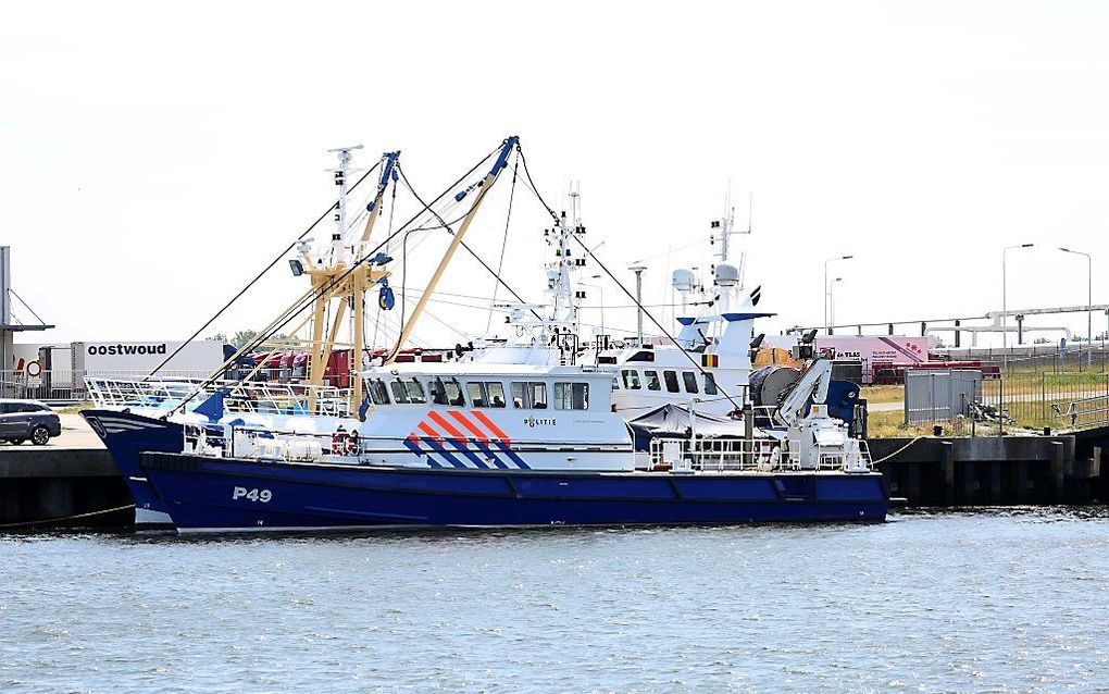 De Urker kotter Z181 ligt in Harlingen aan de wal naast een politieboot. beeld ANP, Ginopress