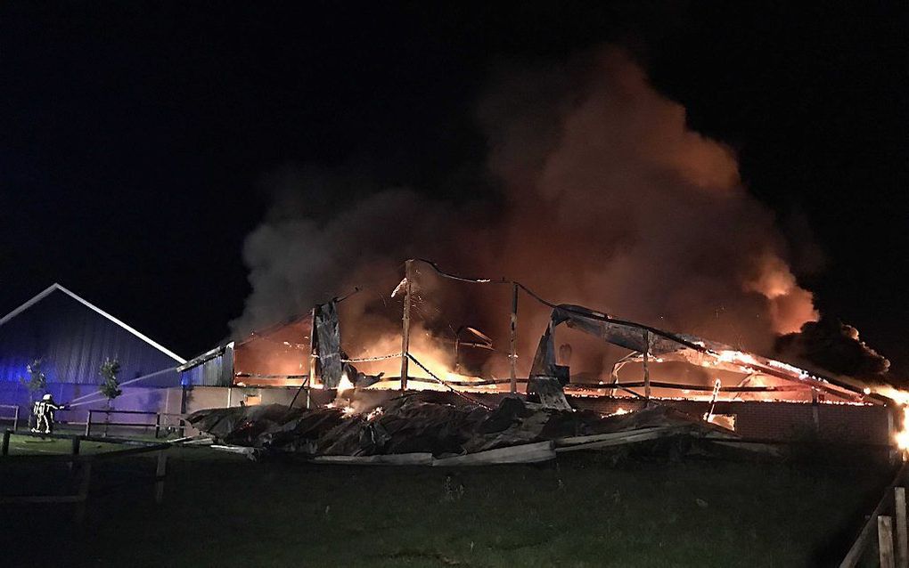 Brandweerlieden blussen in augustus 2017 een grote brand op een varkensfokkerij in Agelo. beeld ANP