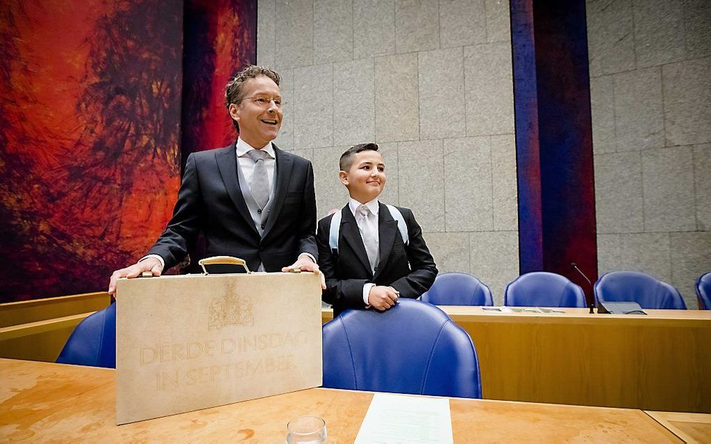 Minister Dijsselbloem van Financien presenteert samen met mini-minister Haci Nuh op Prinsjesdag in de Tweede Kamer het koffertje met de rijksbegroting en miljoenennota. Beeld, Bart Maat