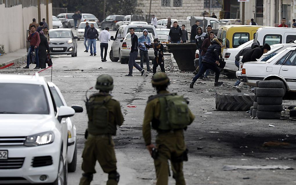 Palestijnen protesteren in Hebron tegen de Amerikaanse erkenning van Jeruzalem als hoofdstad van Israël. De Knesset nam dinsdag een wet aan die opdeling van Jeruzalem moeilijker maakt. beeld EPA, Abed al-Hashlamun