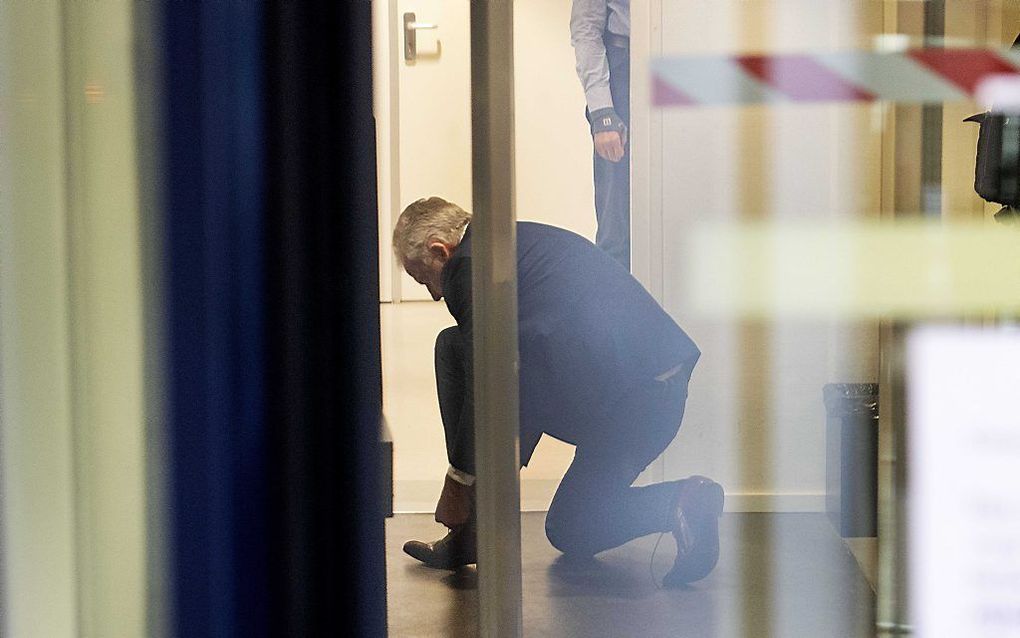 Misdaadverslaggever Peter R. de Vries is voor de tweede keer gearriveerd bij de Bunker voor zijn getuigenverhoor in de strafzaak tegen Willem Holleeder. Op de foto trekt hij zijn schoenen weer aan na de veiligheidscontrole voor bezoekers. beeld ANP, Olaf 