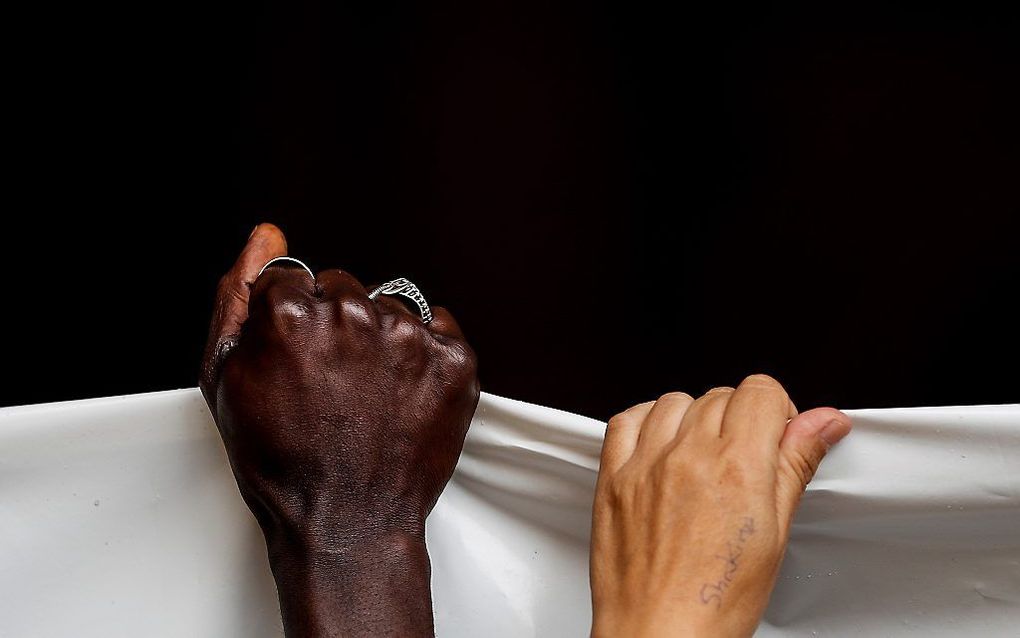 Migranten en actievoerders houden maandag een spandoek vast tijdens een bijeenkomst ter ondersteuning van migranten in San Sebastian, Spanje. beeld EPA