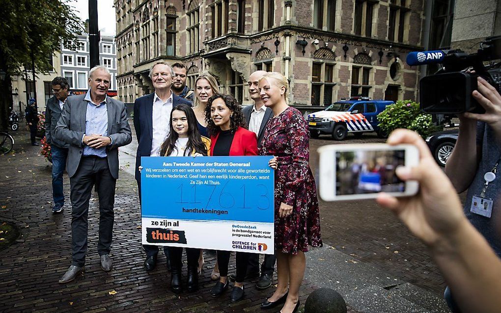 Aloys van Rest (Defence for Children), Hevien en Akhrat (vl.n.r.) bieden een petitie aan Attje Kuiken (Pvda), Bram van Ojik (Groenlinks) en Jasper van Dijk (SP) aan, voorafgaand aan het Algemeen Overleg Vreemdelingen- en Asielbeleid. Ruim 100.000 ondertek