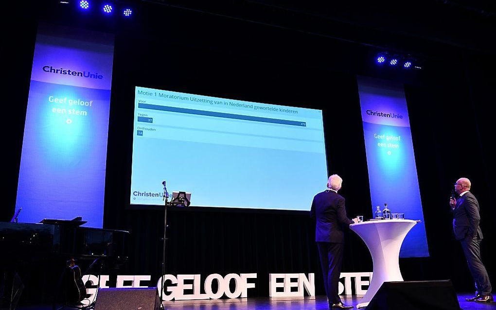 De CU-bestuursleden Piet Adema (l.) en Klaas Tigelaar (r.) volgen de stemmingen over de door de leden ingediende moties en amendementen vanaf het podium. beeld ANP, Eric Brinkhorst