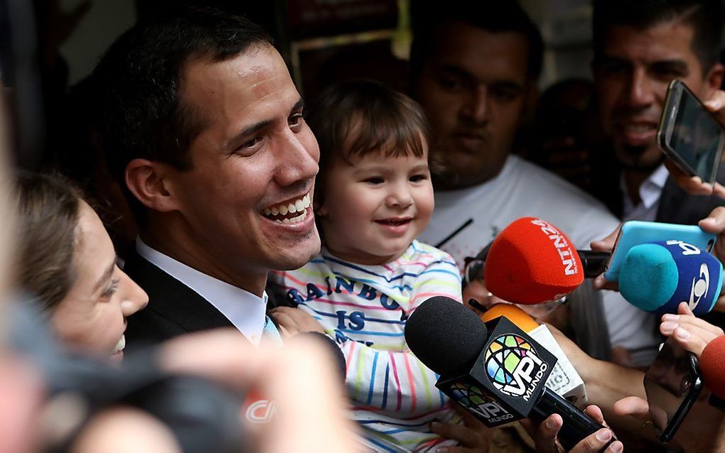 De zelfuitgeroepen president van Venezuela, Juan Guaido, staat de media te woord, geflankeerd door zijn vrouw Fabiana en dochter Miranda. Guaido beschuldigt de Venezolaanse autoriteiten van intimidatie van zijn gezin. beeld EPA, Cristian Hernandez