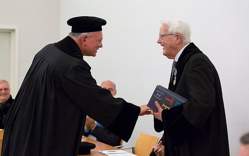 Prof. Selderhuis (l.) overhandigt prof. Van 't Spijker het eerste exemplaar van de nieuwe Lutheruitgave. beeld André Dorst