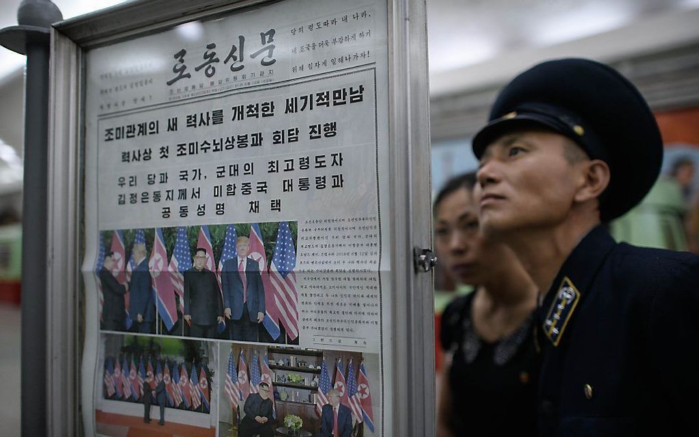 Noord-Koreanen lezen dinsdag het nieuws over de top van Kim Jong-un en Trump. beeld  AFP,  Ed Jones