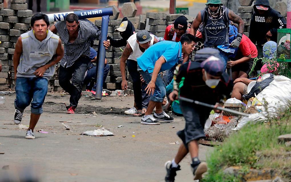 Demonstranten in Nicaragua schuilen achter een barricade tijdens gevechten met de politie, dinsdag in de stad Masaya, op zo’n 35 kilometer afstand van de hoofdstad Managua. beeld AFP, Inti Ocon