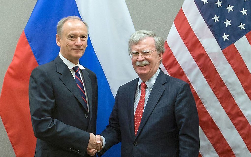 De Amerikaanse veiligheidsadviseur John Bolton (r.) en zijn Russische collega Nikolaj Patroesjev schudden elkaar donderdag in Geneve de hand nadat ze hadden besloten om weer structureel in contact met elkaar te staan via vaste communicatielijnen. beeld  A