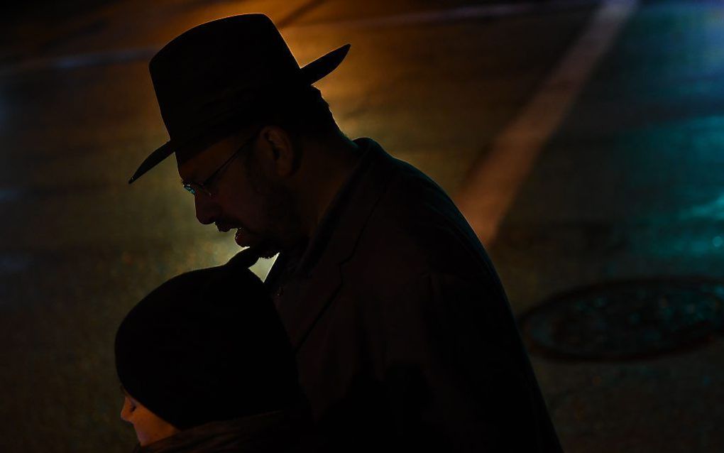 Joden rouwen zondag bij de synagoge in Pittsburgh waar een schutter zaterdag elf mensen doodschoot. beeld AFP, Brendan Smialowski