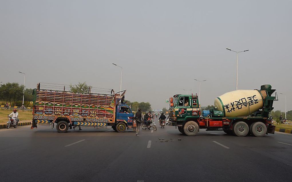 Vrachtwagens blokkeren een hoofdweg naar de Pakistaanse hoofdstad Islamabad. Ze protesteren daarmee tegen de vrijlating van Asia Bibi, een christelijke vrouw die in 2009 gevangen werd genomen omdat zij de profeet Mohammed beledigd zou hebben. beeld AFP