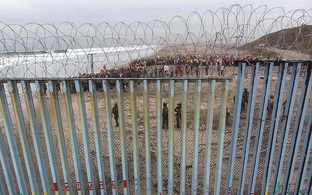 Voorstanders van een ruimhartig immigratiebeleid demonstreren aan de Amerikaans-Mexicaanse grens tegen het restrictieve Amerikaanse optreden ten aanzien van migranten. De foto is gemaakt vanaf de Playas de Tijuana, op Mexicaans grondgebied. beeld AFP