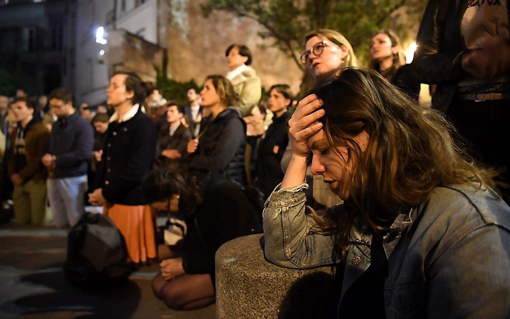 Biddende Parijzenaar, maandag tijdens de brand in de Notre-Dame. beeld AFP, Eric Feferberg