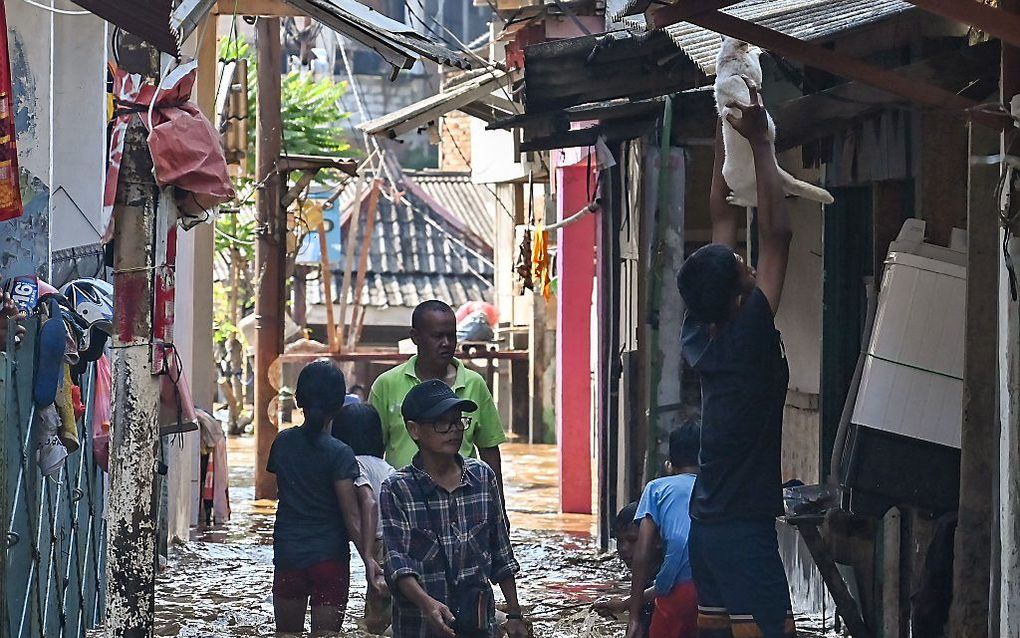 Beeld van een ondergelopen straatje in de Indonesische hoofdstad Jakarta.  Onder andere vanwege de bele onderstromingen die de hoofdstad teisteren, zoekt de regering naar een andere locatie voor een hoofdstad. beeld  AFP,  Bay Ismoyo