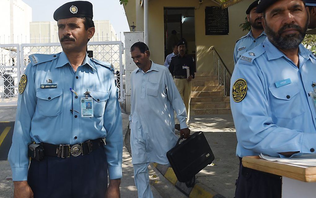 De echtgenoot van Asia Bibi, Ashiq Masih, verlaat donderdag onder politiebescherming het hooggerechtshof in Islamabad. beeld AFP, Farooq Naeem