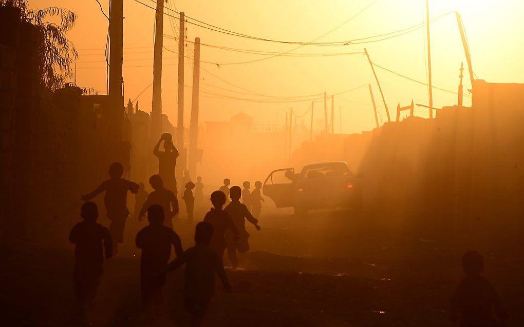 Afghaanse kinderen spelen tijdens zonsondergang in de stad Zaranj . beeld AFP