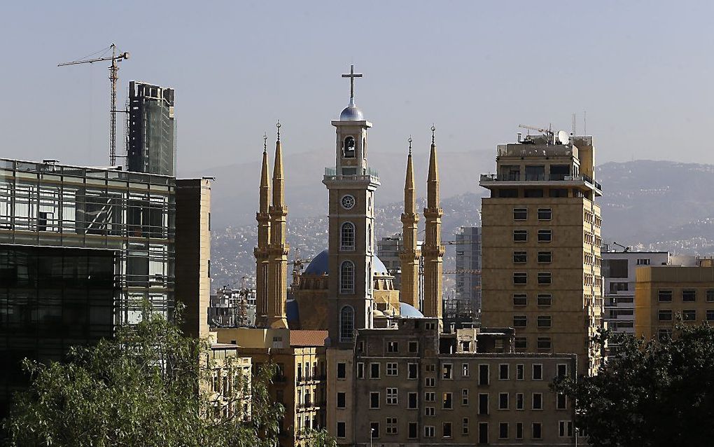 BEIROET. De St.-Georgekathedraal in Beiroet heeft sinds kort een toren van 72 meter. Het bouwwerk is nu even hoog als de vier minaretten van de ernaast gelegen Mohammed al-Aminmoskee. beeld AFP, Joseph Eid