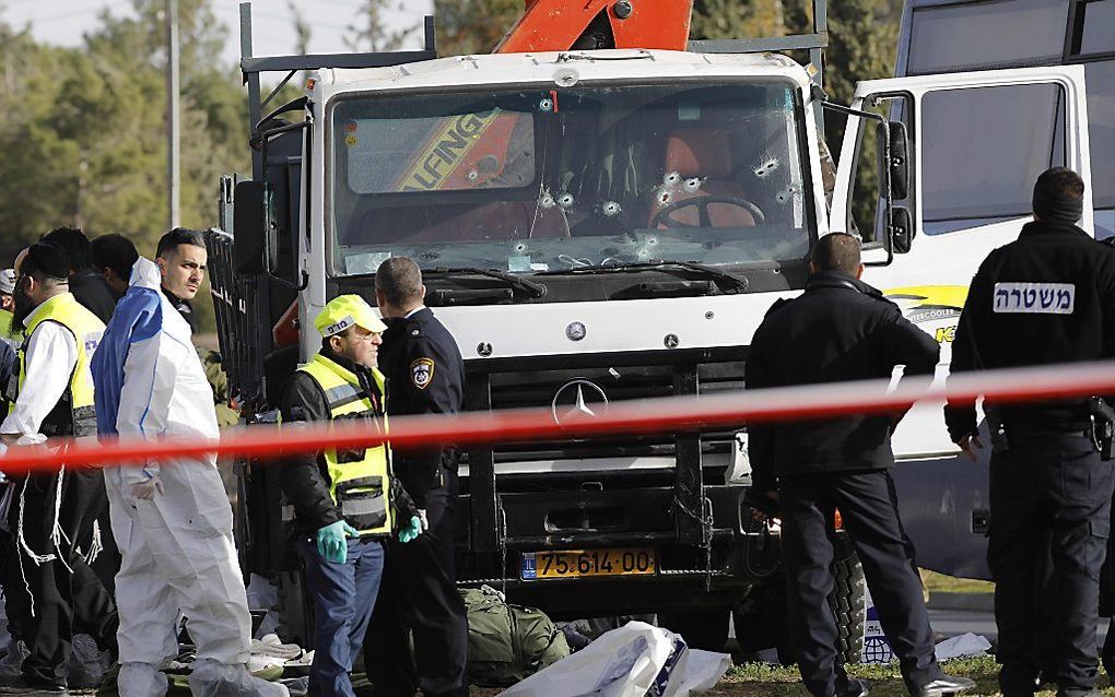 JERUZALEM. Israëlische politieagenten inspecteren de vrachtwagen waarmee een Palestijn gisteren een aanslag op een groep militairen pleegde. beeld AFP, Menahem Kahana