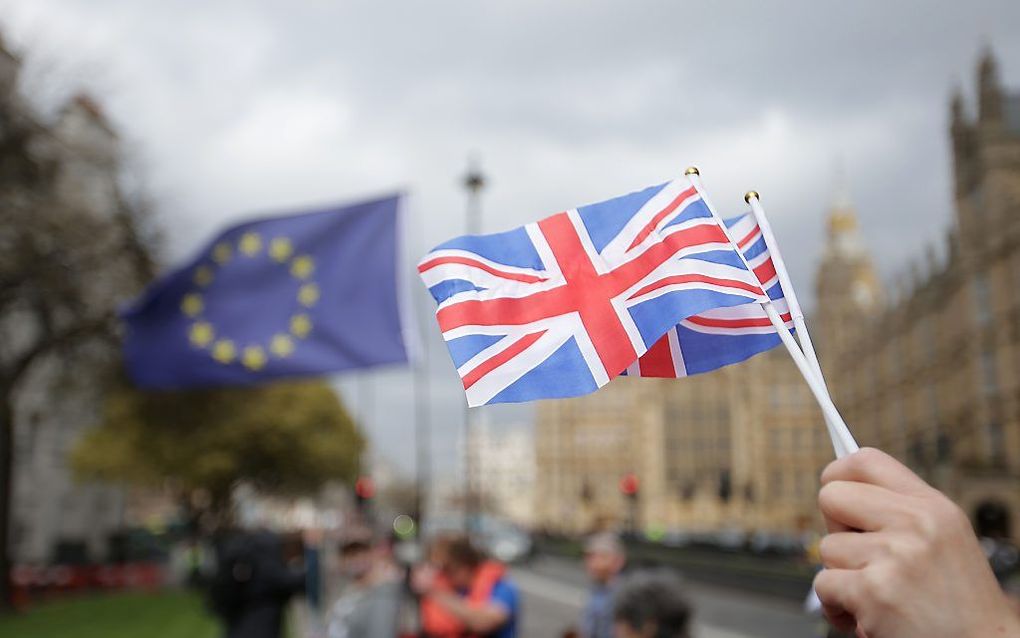 LONDEN. Een tegenstander van de Brexit toonde zijn opvatting met behulp van twee vlaggetjes, een van de EU en een van het Verenigd Koninkrijk.  AFP, Daniel Leal Olivao