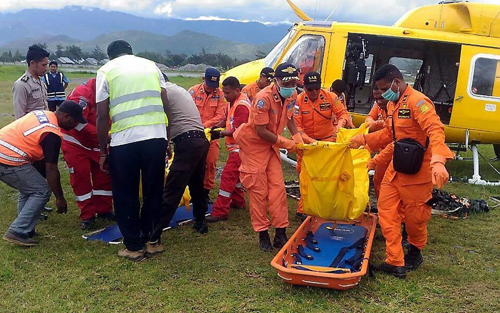 Met een helikopter worden de lichamen van de slachtoffers van het vliegongeval donderdag naar Wamena gebracht. beeld AFP/STR