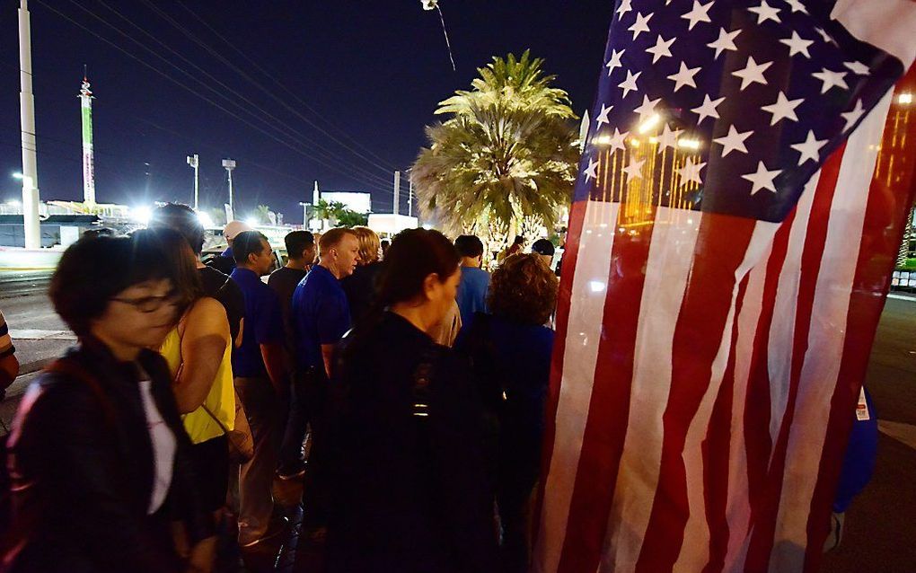 LAS VEGAS. Mensen rouwen bij een inderhaast opgericht monument bij het Mandalay Bay hotel in Las Vegas, waar een man maandag 58 mensen en zichzelf doodschoot. beeld AFP, Robyn Beck