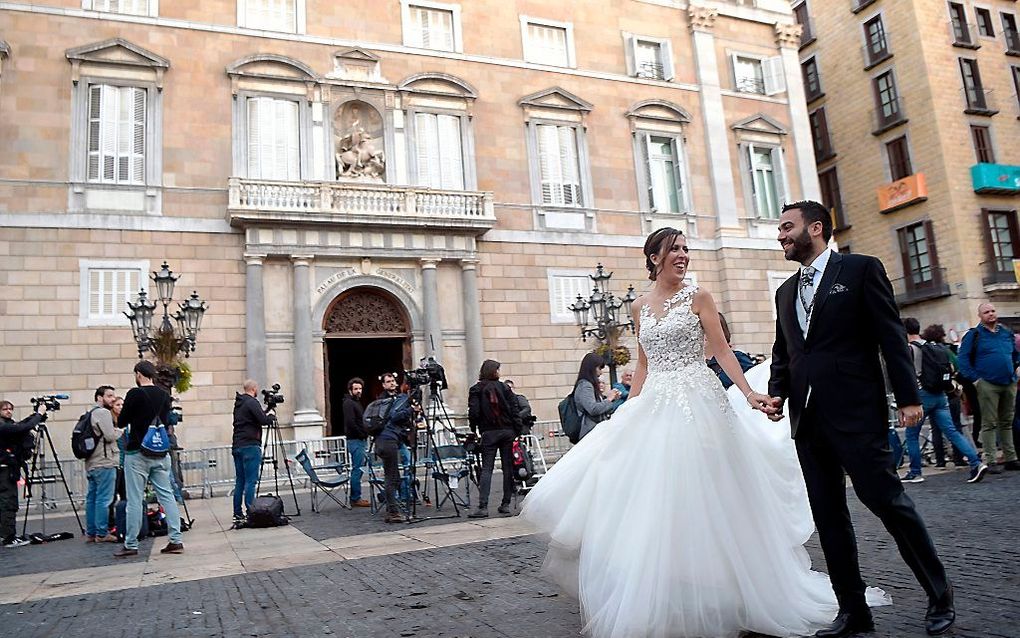 Een bruidspaar, maandagmorgen, voor de 'Generalitat', het regeringscentrum, in Barcelona. beeld AFP