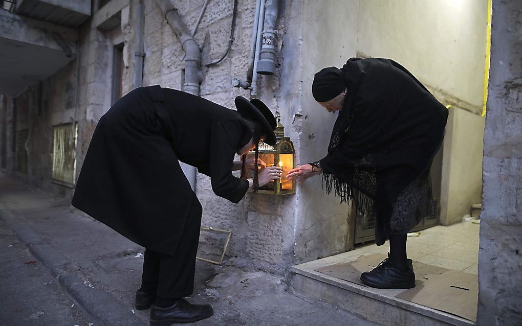 Orthodoxe Joden steken kaarsen aan tijdens de tweede nacht van het Chanoekafeest in Mea Shearim, een orthodoxe wijk van Jeruzalem. beeld AFP