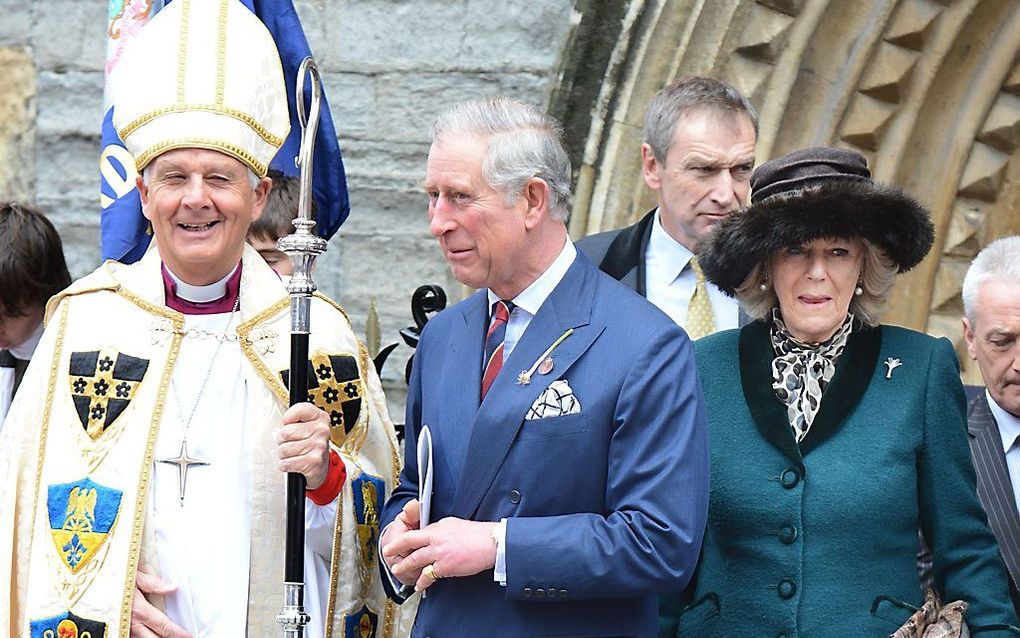 Prins Charles (midden) en Camilla (rechts) verlaten samen met de aartsbisschop van Wales, Barry Morgan (links) de John The Baptist City Parish Church in Cardiff. beeld AFP