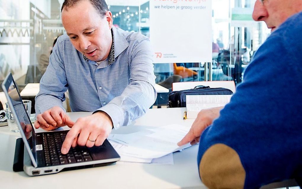 „Niet alleen ingewijden, maar ook burgers die daar enige moeite voor willen doen, moe-ten de belastingregelgeving kunnen doorzien.” Foto: een medewerker van Nationale-Nederlanden helpt een belastingplichtige bij het invullen van zijn aangifte inkomsten-be