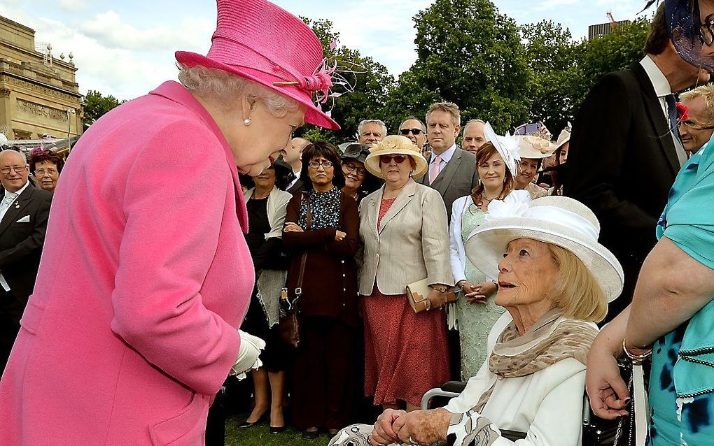 De Britse koningin Elizabeth II spreekt in 2015 met Gena Turgel tijdens een tuinfeest op Buckingham Palace. beeld AFP