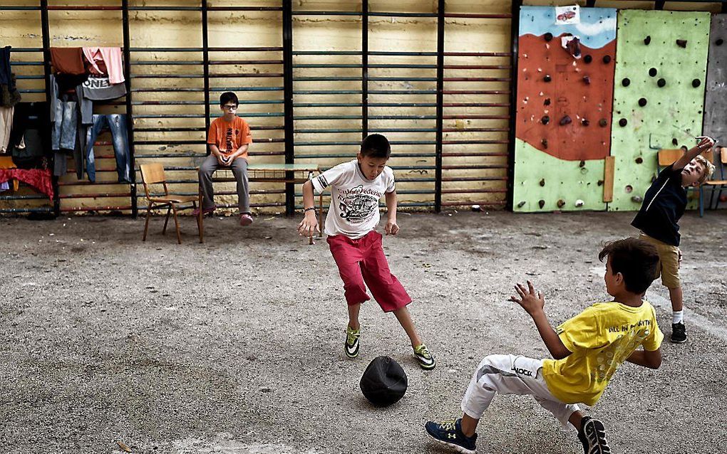 Vluchtelingenkinderen spelen in een school in Athene.   beeld AFP, Aris Messinis