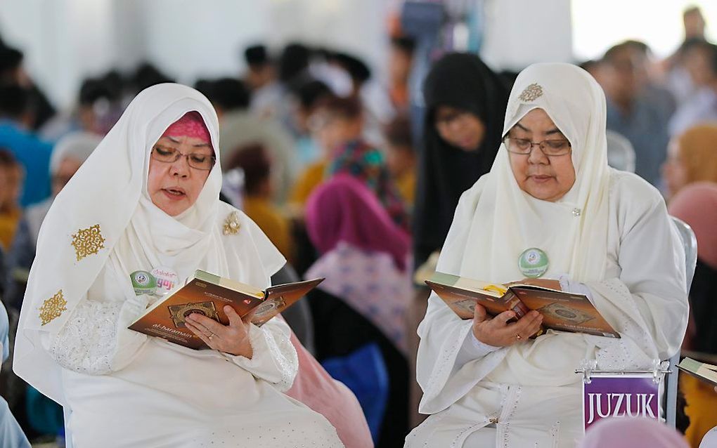 Moslimvrouwen reciteren de Koran in de moskee van Putrajaya, Maleisië.         Beeld ANP