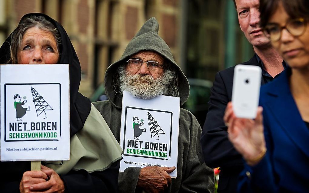 Actievoerders houden voor de Tweede Kamer een protest tegen gasboringen voor Schiermonnikoog. beeld ANP, Marten van Dijl