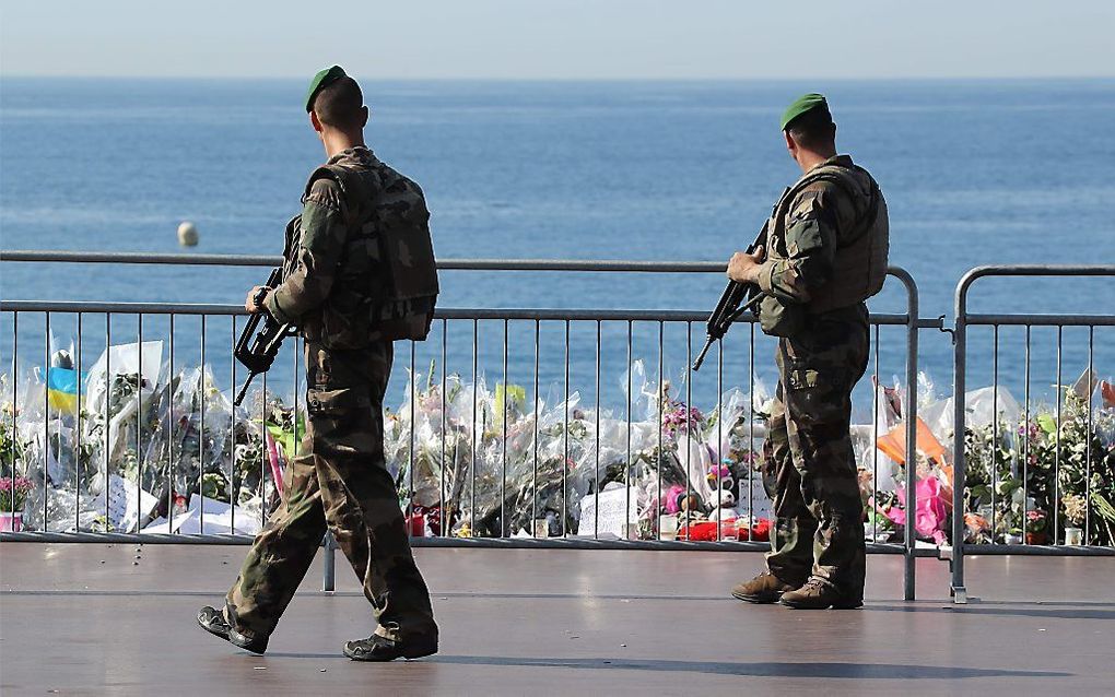 Militairen passeren de bloemenzee op de boulevard van Nice. Beeld AFP