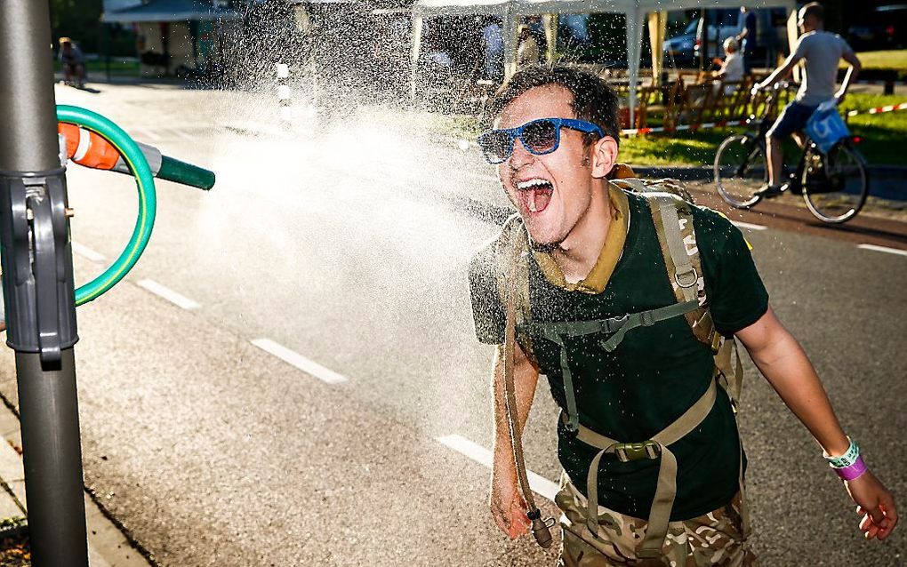 Een deelnemer aan de Nijmeegse Vierdaagse zoekt verkoeling. Beeld ANP