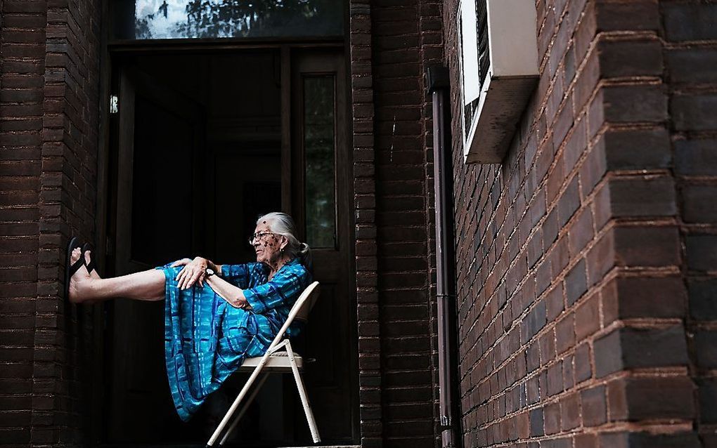 Een oudere Amerikaanse dame op de stoep van haar woning in Philadelphia, waar deze week de conventie van de Democraten plaatsvindt. beeld AFP