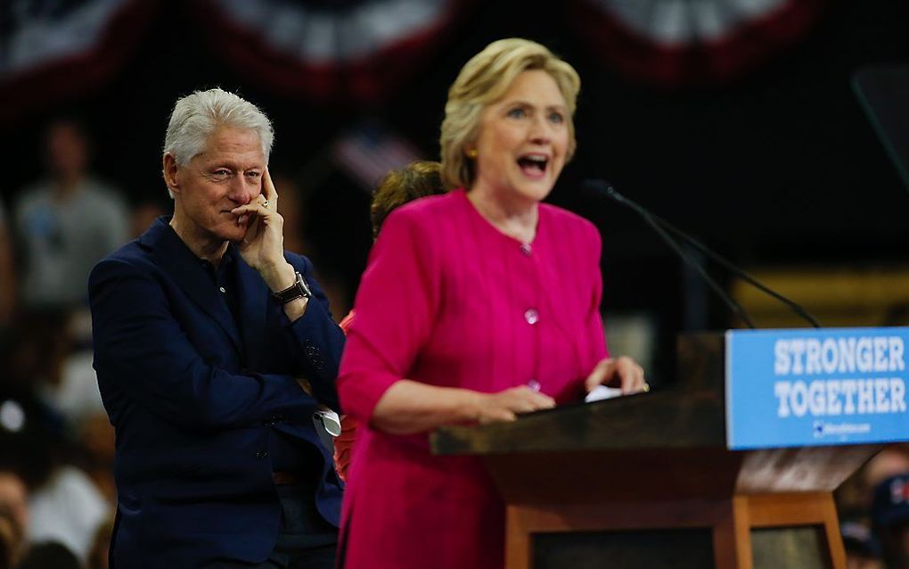 Hillary Clinton met op de achtergrond haar echtgenoot Bill. beeld AFP