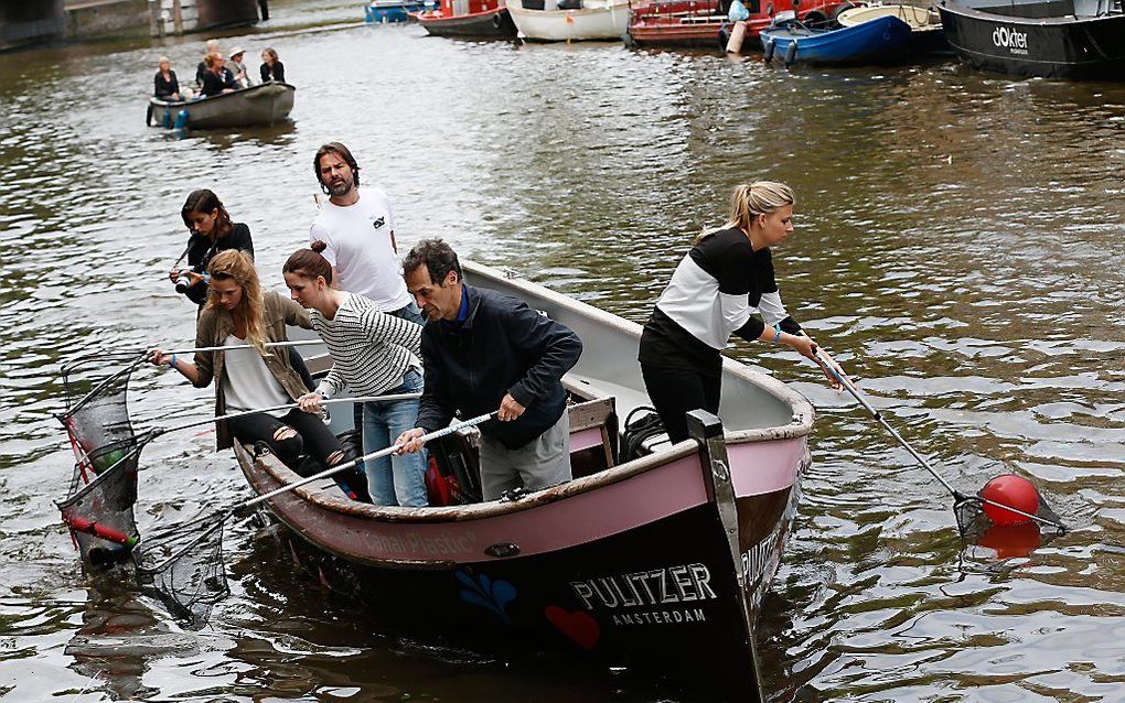 AMSTERDAM. Vrijwilligers van de organisatie Plastic Whale ruimen in de grachten afval op dat door feestvierders werd achtergelaten. beeld ANP Bas Czerwinski