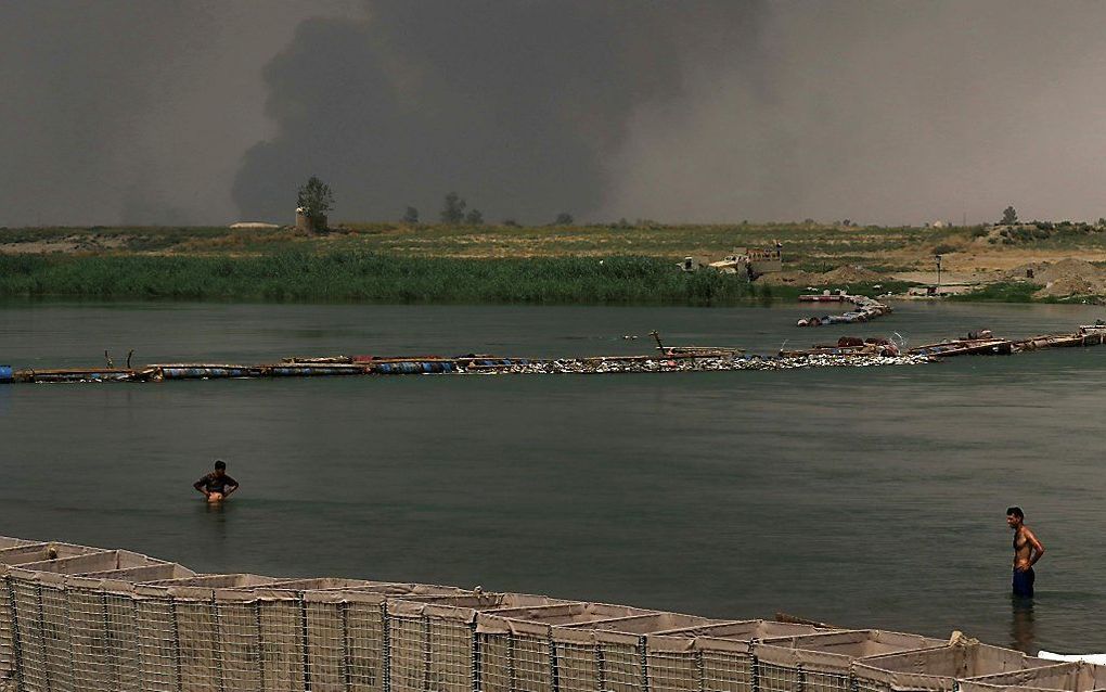 De Tigris, met op de achtergrond brandende olievelden. beeld AFP