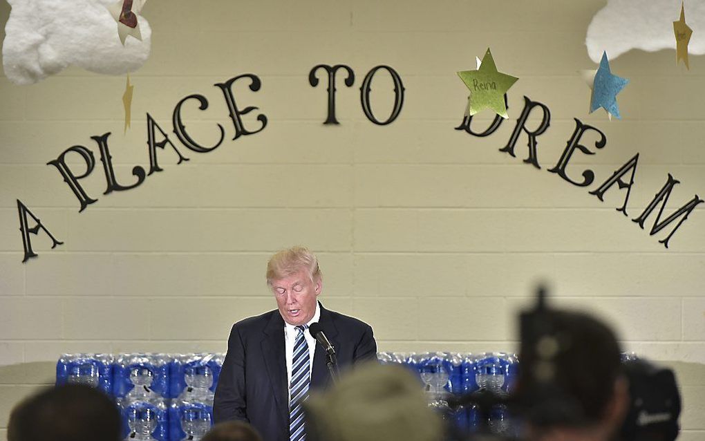 Donald Trump spreekt in de Bethel United Methodist Church in Flint. Achter hem flessen bronwater. De drinkwatervoorziening is een probleem in het door economische malaise getroffen Flint. beeld AFP