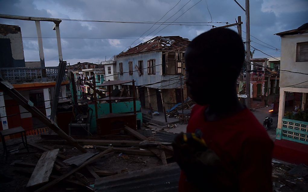 Een jongen kijkt naar de schade die orkaan Matthew heeft aangericht in zijn woonplaats in west-Haiti. beeld AFP