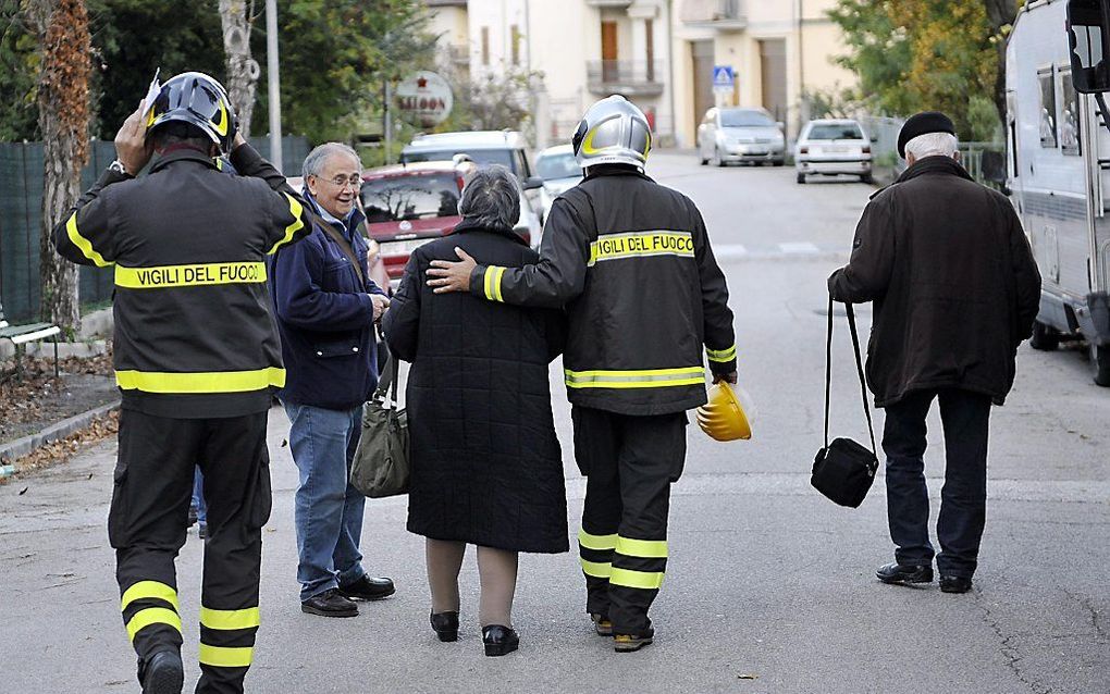 Brandweermannen evacueren bewoners van Pieve Torina. beeld EPA