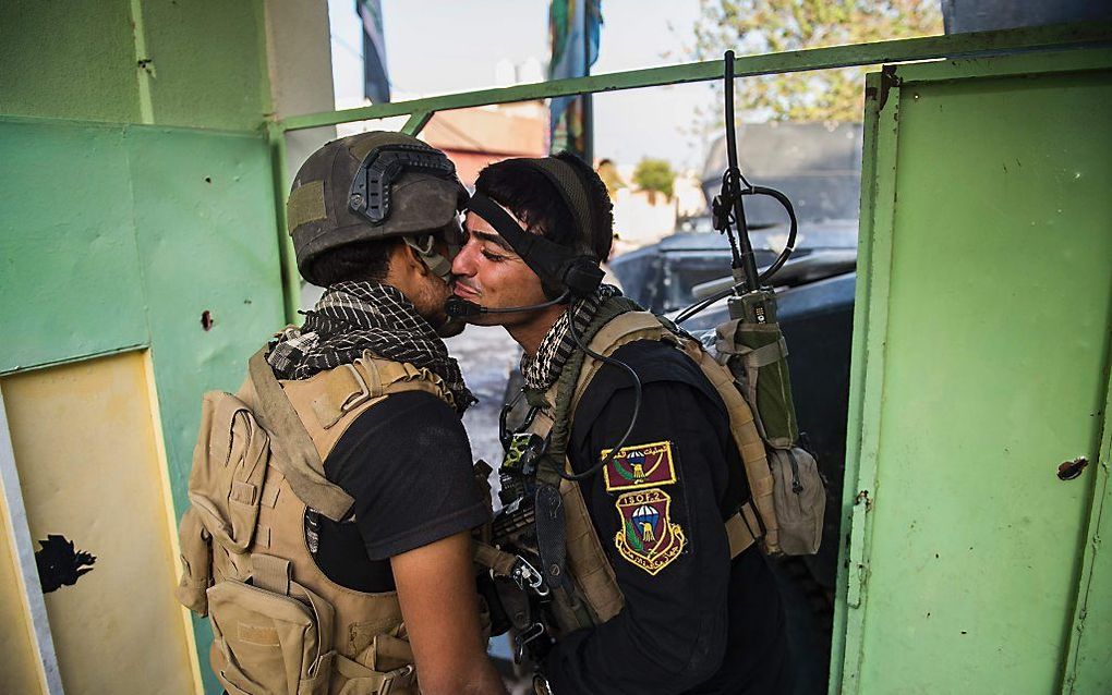 Iraakse militairen begroeten elkaar zaterdag in Mosul. beeld AFP